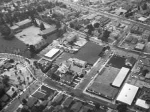 St. Dominic's Catholic Church (at center left), located at 2002 Merton Avenue in Eagle Rock; view is looking southwest. St. Dominic's Catholic School is visible across from the church. Eagle Rock Elementary School, located at 2057 Fair Park Avenue, is visible at upper left; Eagle Rock Boulevard runs middle top to middle right; Caspar Avenue is middle right to upper middle; Maywood Avenue curves from bottom right to middle left; Chickasaw Avenue is at lower left corner and jars from middle left to upper center; Colorado Boulevard is at bottom right. Photograph dated September 19, 1957.