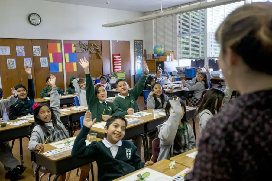 Students raising their hands in a St. Dominic classroom